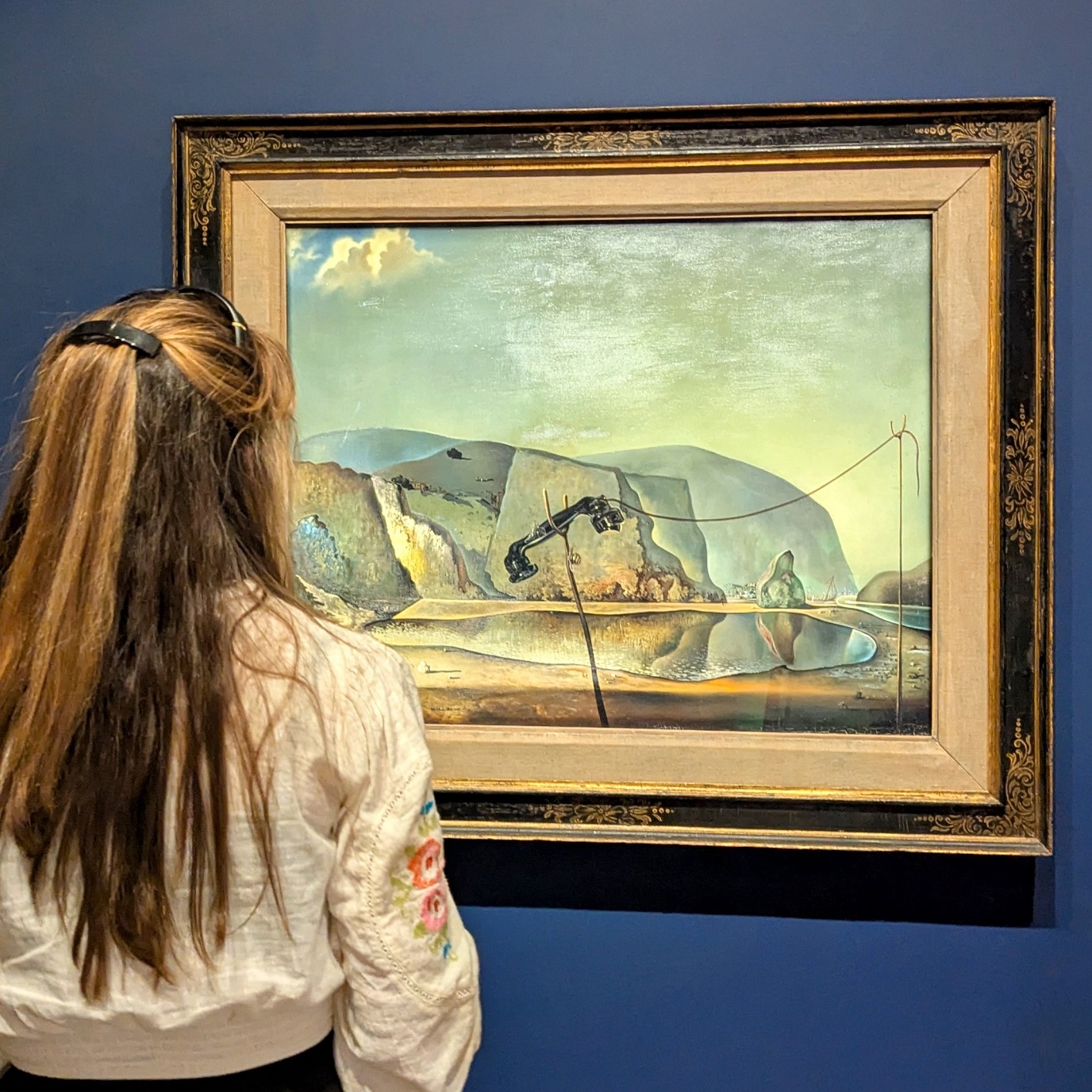 A female visitor looking at Mountain Lake by Salvador Dali on display at The Box Plymouth